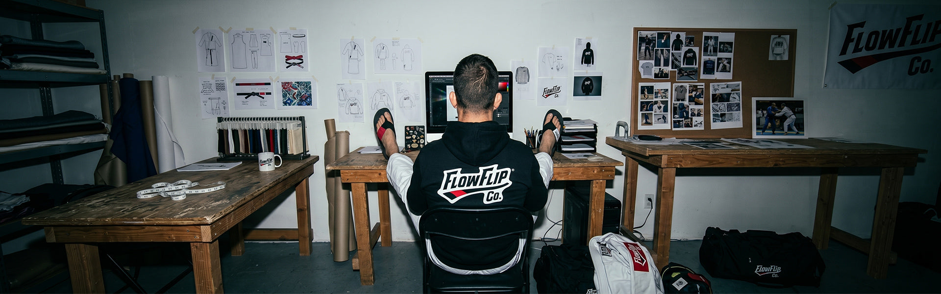 FlowFlip Co. workspace with product sketches, Jiu Jitsu gear, and BJJ flip flops on the desks