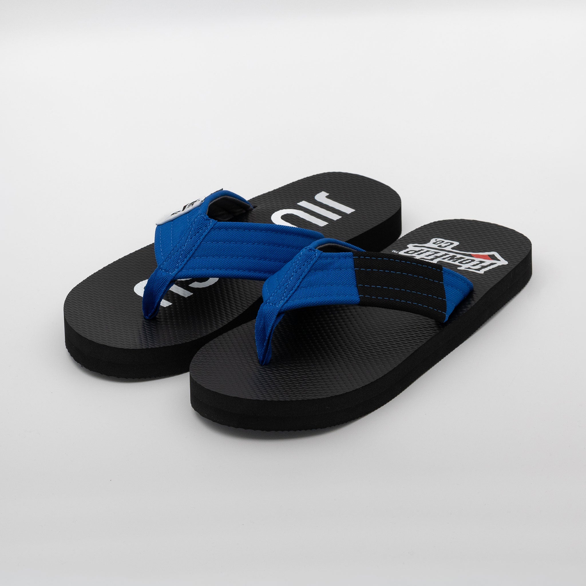 Angled pair view of blue belt BJJ flip flops with blue strap and black rank bar.