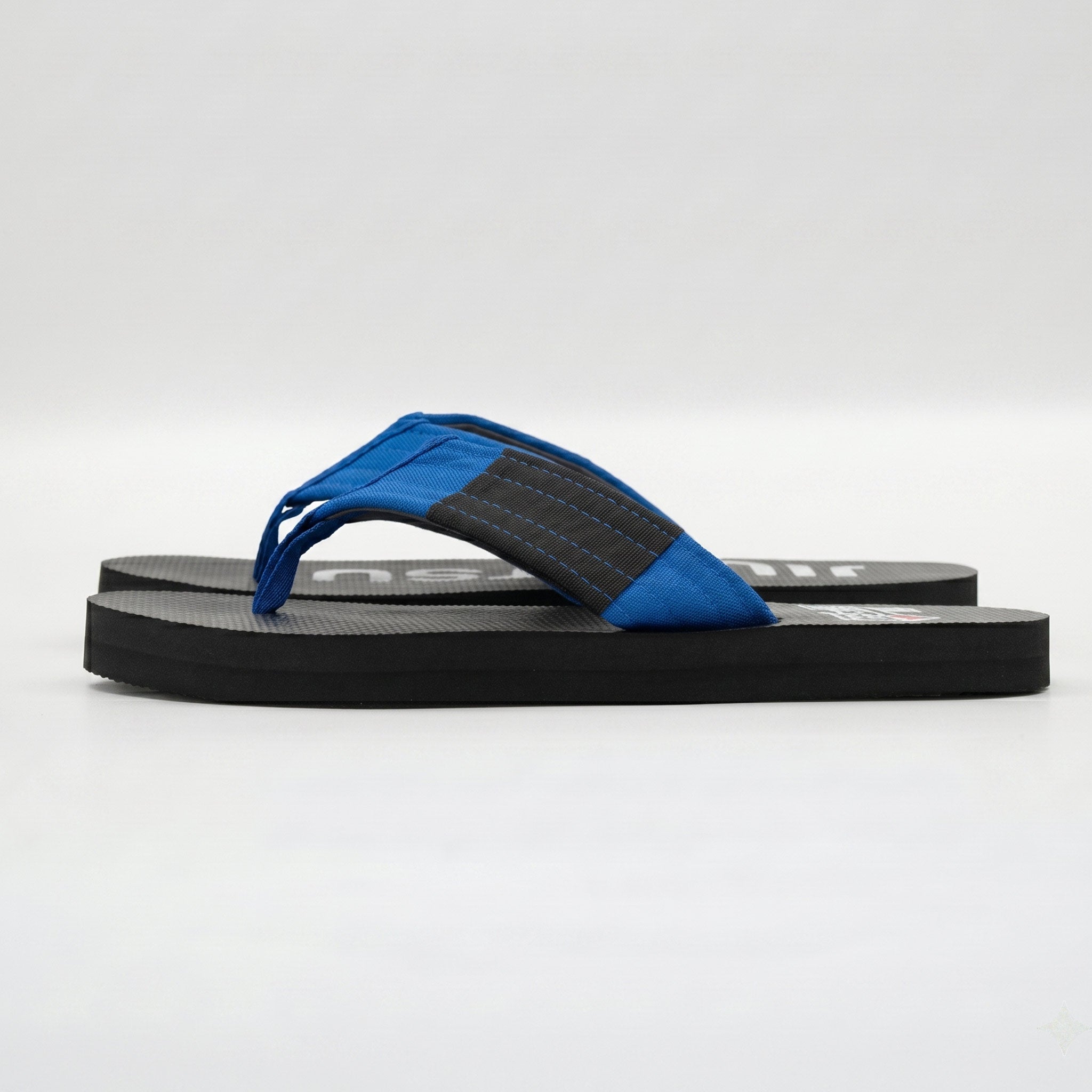 Side view of blue belt BJJ flip flops showing blue strap and textured sole.