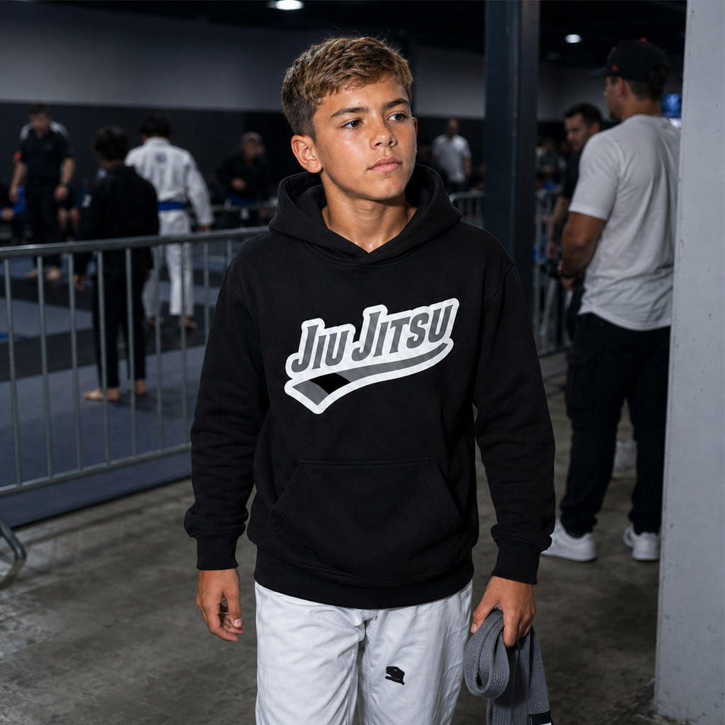 Person wearing a black 'Jiu Jitsu' grey belt hoodie in a tournament setting