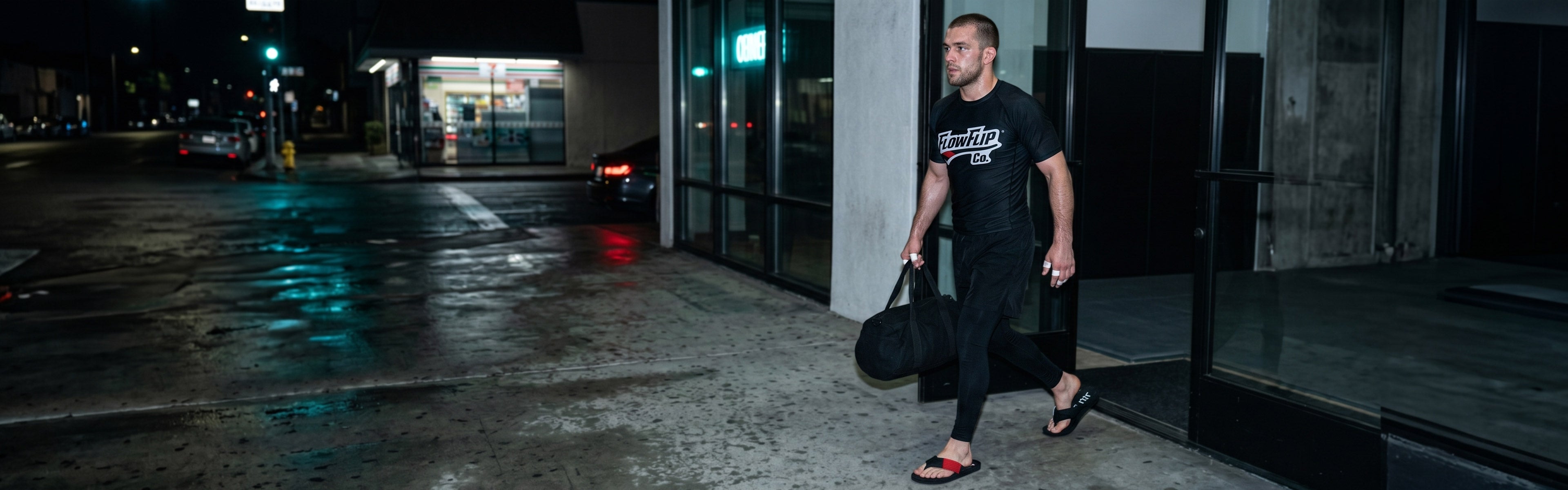 BJJ practitioner wearing FlowFlip apparel and black belt flip flops outside the academy after training