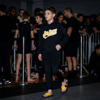 Yellow belt Jiu Jitsu hoodie worn with matching yellow belt BJJ flip flops in tournament event setting.