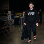 Black Jiu Jitsu hoodie worn at a BJJ tournament.