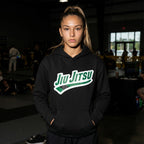 Green belt Jiu Jitsu hoodie worn in a BJJ academy setting with green rank chest artwork visible.