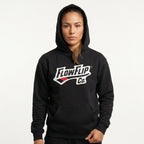 Black Jiu Jitsu hoodie worn in studio with FlowFlip Co. chest logo visible.